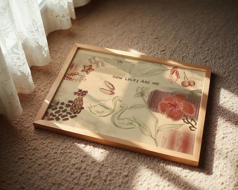 Puede incluir: Una impresi&oacute;n art&iacute;stica enmarcada con un marco de madera clara. La obra presenta ilustraciones de cisnes, flores y otros elementos decorativos en tonos rojos, beige y marr&oacute;n. El texto "HOW LUCKY ARE WE" es visible.
