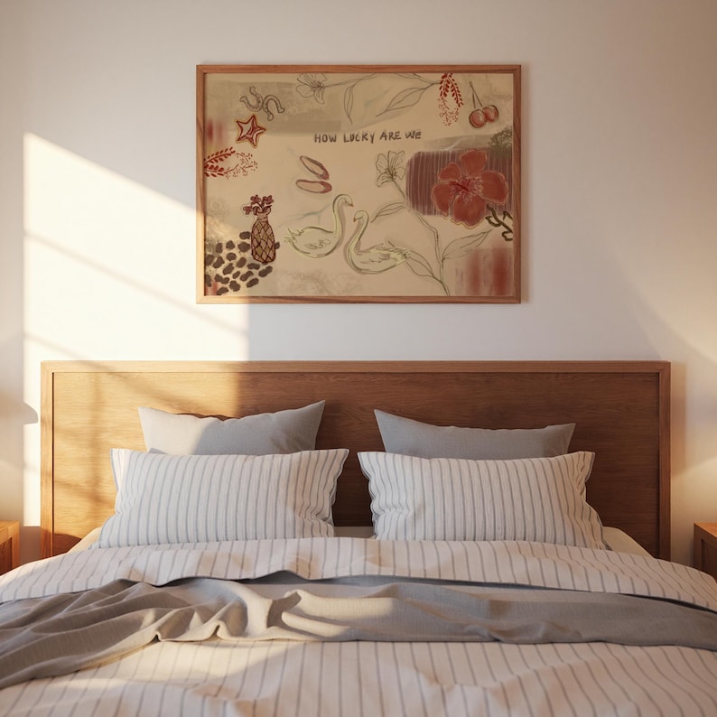 Puede incluir: Una escena de dormitorio con un cabecero de madera y una cama con ropa de cama a rayas y almohadas grises. Encima de la cama cuelga una obra de arte enmarcada con ilustraciones de una estrella, cerezas, flores y cisnes. La obra de arte incluye el texto "HOW LUCKY ARE WE".