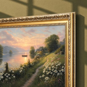 May include: A landscape painting in an ornate gold frame depicting a sunset over a calm lake with a small boat, a cottage nestled among trees, and a dirt path lined with white daisies and green foliage extending into the distance.