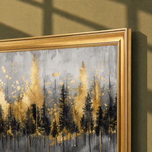 May include: A framed wall art piece featuring a forest scene with black pine tree silhouettes against a textured gray background, accented by splatters and washes of metallic gold paint throughout the composition, enclosed in a gold frame.