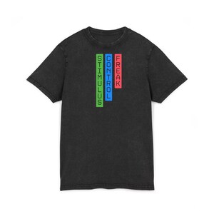 Puede incluir: Camiseta negra con las palabras "STIMULUS", "CONTROL" y "FREAK" apiladas verticalmente en verde, azul y rojo. La camiseta tiene un aspecto ligeramente descolorido, de estilo vintage.