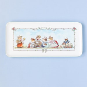 May include: Rectangular white ceramic serving tray with a whimsical illustration of anthropomorphic animals in vintage clothing. The scene depicts a picnic with a floral border and ribbon accents. The tray has a light green edge.