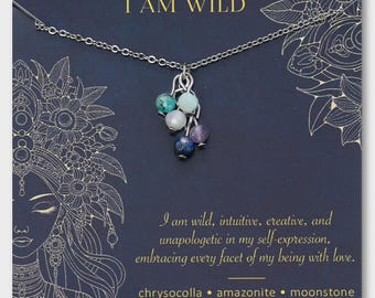 Può includere: Una collana d'argento con un gruppo di perline di pietre preziose colorate. Le perline includono crisocolla, amazzonite, pietra di luna, ametista e lapislazzuli. La carta dietro la collana dice "I AM WILD".