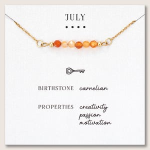 May include: A set of three ceramic mugs with a speckled, cream-colored glaze. Each mug features a different hand-painted design: a blue and green leaf, a yellow flower, and a red berry. The mugs have a simple, rounded shape.