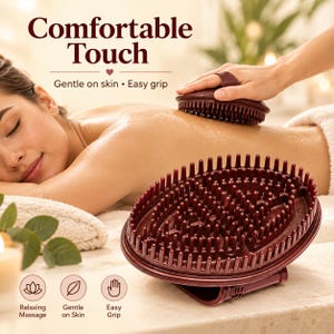Puede incluir: Un cepillo de masaje corporal ovalado de color granate oscuro con numerosas cerdas de silicona flexibles y una correa. El texto dice Comfortable Touch, Gentle on skin, Easy grip, Relaxing Massage, Gentle on Skin y Easy Grip.
