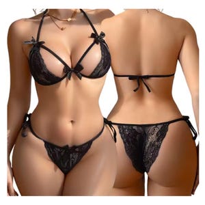 Op de afbeelding: Een zwarte kanten lingerieset bestaande uit een halter-bh met uitsparingen, dunne bandjes en kleine decoratieve strikjes. Het bijpassende broekje in tanga-stijl heeft zijstrikjes en kanten panelen, getoond in voor- en achteraanzicht.