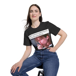 May include: Dark gray t-shirt featuring a graphic of Sarah Connor with the text "Sarah Connor watching you use AI for everything." The shirt is made of a soft material and has a classic crew neck.