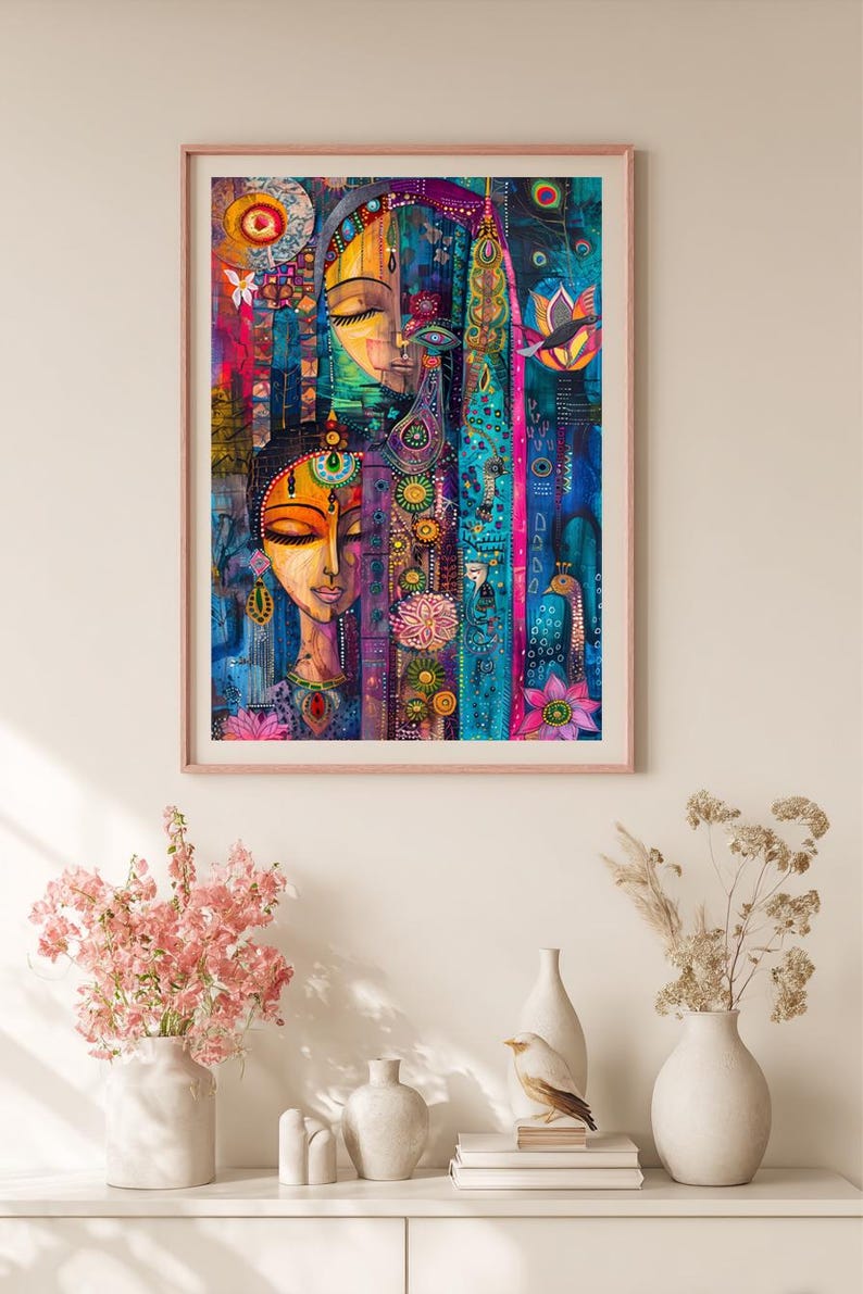 May include: A framed art print depicting a colourful, abstract portrait of two women with closed eyes. The artwork uses vibrant blues, pinks, and yellows, with floral and geometric patterns. The print is displayed above a white shelf with vases and decorative items.