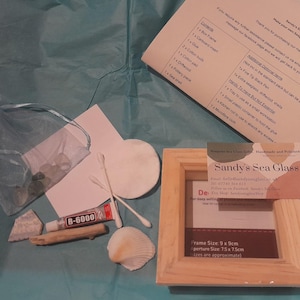 May include: A DIY sea glass picture kit with a wooden frame, glue, cotton swabs, driftwood, a seashell, and a printed instruction sheet. The kit includes a frame measuring 9 x 9 cm, with an aperture size of 7.5 x 7.5 cm.
