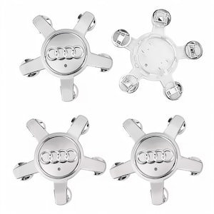 Puede incluir: Cuatro tapacubos plateados de Audi. Cada tapacubos tiene un dise&ntilde;o de estrella de cinco puntas con el logotipo de Audi en el centro. Se muestra un tapacubos desde la parte trasera, revelando los clips de montaje.