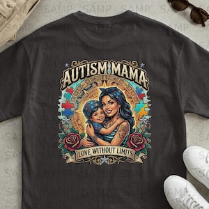 Op de afbeelding: Donkergrijs T-shirt met een kleurrijke afbeelding. Het ontwerp toont de tekst "AUTISM MAMA" boven een illustratie van een moeder en kind die elkaar omarmen. Het ontwerp bevat puzzelstukjes, rozen en de zin "LOVE WITHOUT LIMITS" op een banner.