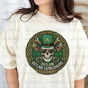 May include: Cream-colored t-shirt featuring a circular graphic with a skull wearing sunglasses and a green leprechaun hat with a shamrock. The graphic includes crossed pistons, Celtic knotwork, and the text "OUTLAW LEPRECHAUNS MOTORCYCLE CLUB."
