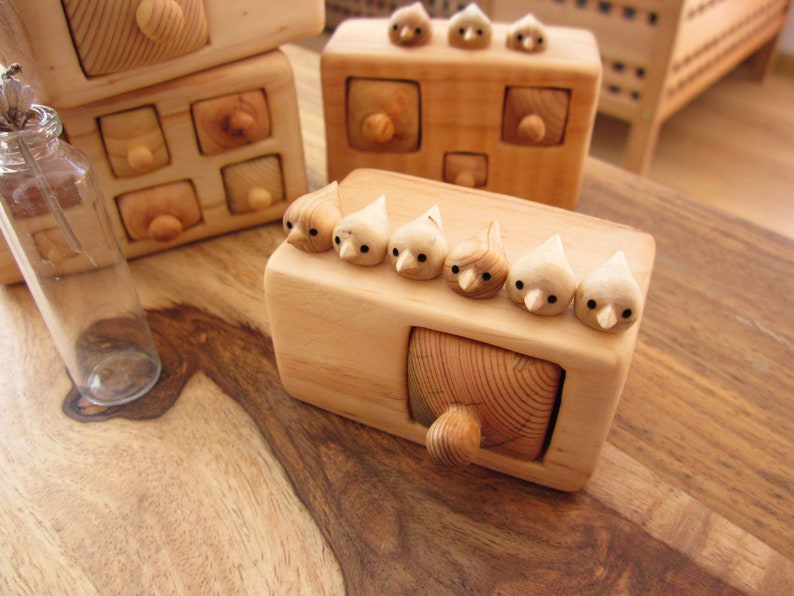 Small wooden box with one drawer and flock of six birds on the top. The miniature box, drawers and birds are hand carved from wood. The drawer can fit a rings or other small jewelry. A very sweet hand carved gift for a special ocasions.