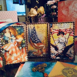 May include: Three vintage patriotic cards with red, white, and blue colors. The cards feature images of women holding American flags and the text "Fourth of July Greetings" and "But his soul goes marching on."