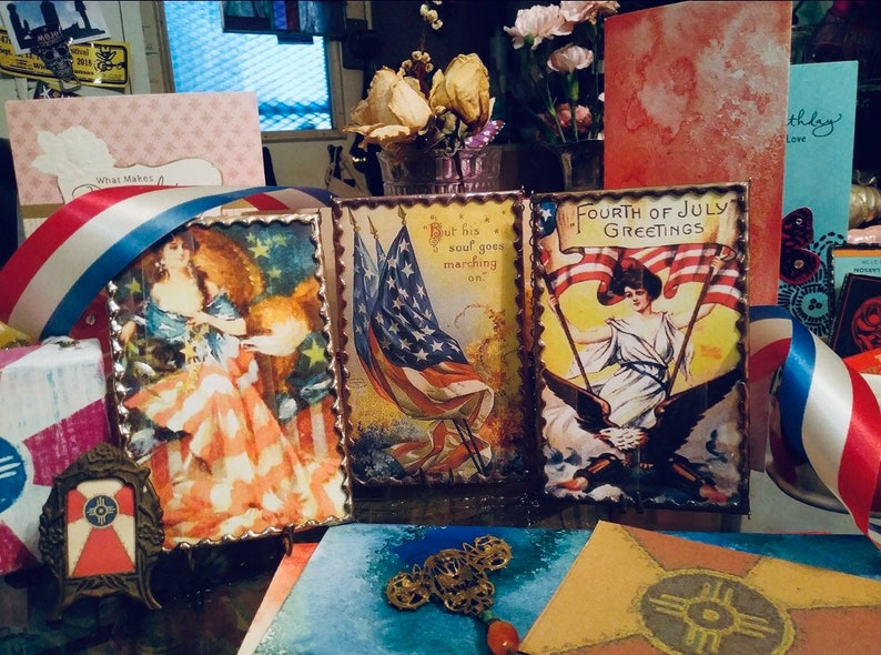 May include: Three vintage patriotic cards with red, white, and blue colors. The cards feature images of women holding American flags and the text "Fourth of July Greetings" and "But his soul goes marching on."