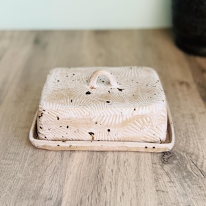 Handmade ceramic butter dish with lid, embossed flower pattern, SPECKLED CREAM BROWN glaze, placed on a wooden board