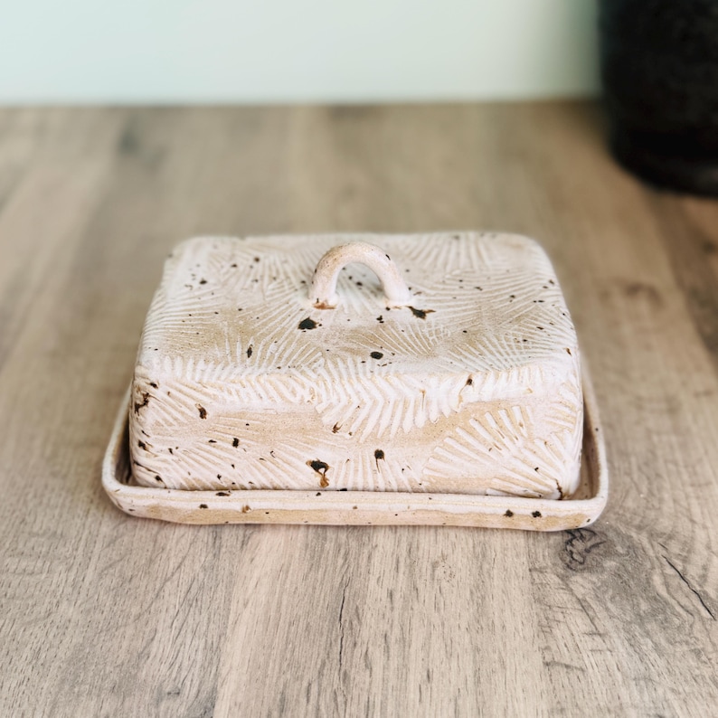 Handmade ceramic butter dish with lid, embossed flower pattern, SPECKLED CREAM BROWN glaze, placed on a wooden board
