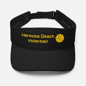 May include: Black visor with a yellow embroidered volleyball and the text "Hermosa Beach Volleyball".