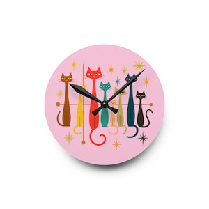 May include: A pink wall clock with a retro design featuring stylized cats in various colors. The cats are arranged in a row, with starburst accents. The clock hands are black.