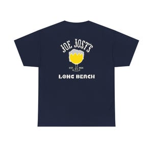 Może przedstawiać: Granatowa koszulka z grafiką szklanki piwa i białym napisem "JOE JOST'S LONG BEACH EST. 1924". Koszulka wykonana jest z miękkiego, wygodnego materiału.