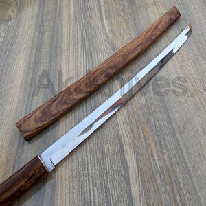 May include: A Japanese-style sword with a polished steel blade and a wooden handle and sheath. The handle and sheath are a dark brown colour with a wood grain pattern. The blade is straight and has a sharp edge.