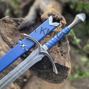 May include: A detailed image of a sword with a patterned blade and a blue leather-wrapped handle. The sword is accompanied by a matching blue sheath. The text "AK KNIVES" is visible on the sheath.