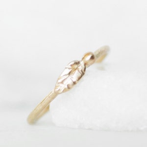 Puede incluir: Un delicado anillo de oro con un peque&ntilde;o dise&ntilde;o de hoja. El anillo es simple y elegante, perfecto para el uso diario.