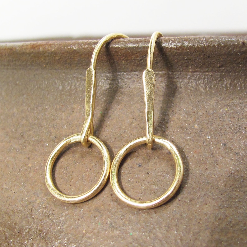 May include: A pair of gold hoop earrings with a simple, minimalist design. The hoops are small and delicate, and the earrings are perfect for everyday wear.