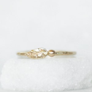 Puede incluir: Un delicado anillo de oro con un peque&ntilde;o dise&ntilde;o de hoja. El anillo es simple y elegante, perfecto para el uso diario.