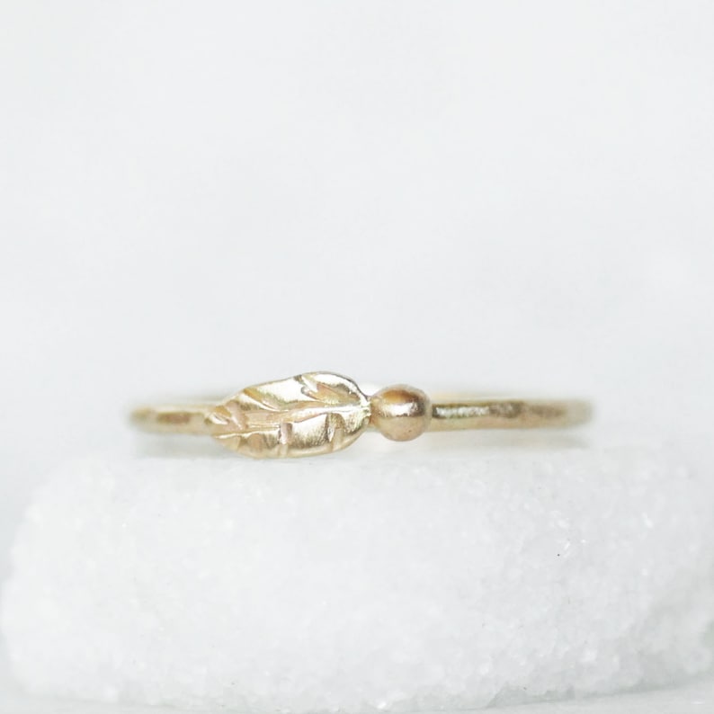 Puede incluir: Un delicado anillo de oro con un peque&ntilde;o dise&ntilde;o de hoja. El anillo es simple y elegante, perfecto para el uso diario.