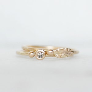 Puede incluir: Un delicado anillo de oro con un peque&ntilde;o diamante y un dise&ntilde;o de hoja. El anillo est&aacute; hecho de oro de 14 quilates y presenta un estilo simple y elegante.