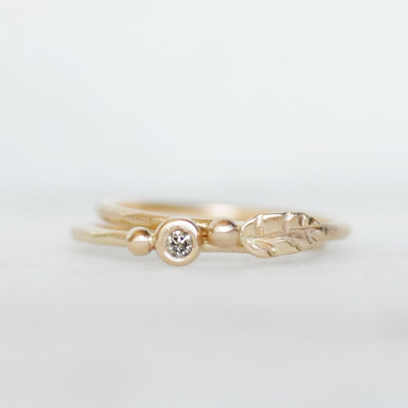 Puede incluir: Un delicado anillo de oro con un peque&ntilde;o diamante y un dise&ntilde;o de hoja. El anillo est&aacute; hecho de oro de 14 quilates y presenta un estilo simple y elegante.