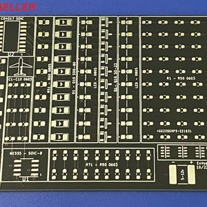 Puede incluir: Una placa de circuito impreso negra con texto y marcas blancas. La placa tiene una variedad de componentes, incluyendo resistencias, condensadores y circuitos integrados. El texto en la placa incluye "C04017 SOIC", "C1-C10 0603", "R50 0603", "NE555 SOIC-8", "871 R90 0603", "LED-080 0805", "91-910 50-23", "LED-0805", "4662206AP9-221031", "RN1-RNS 1206", "421-5", "10/22".