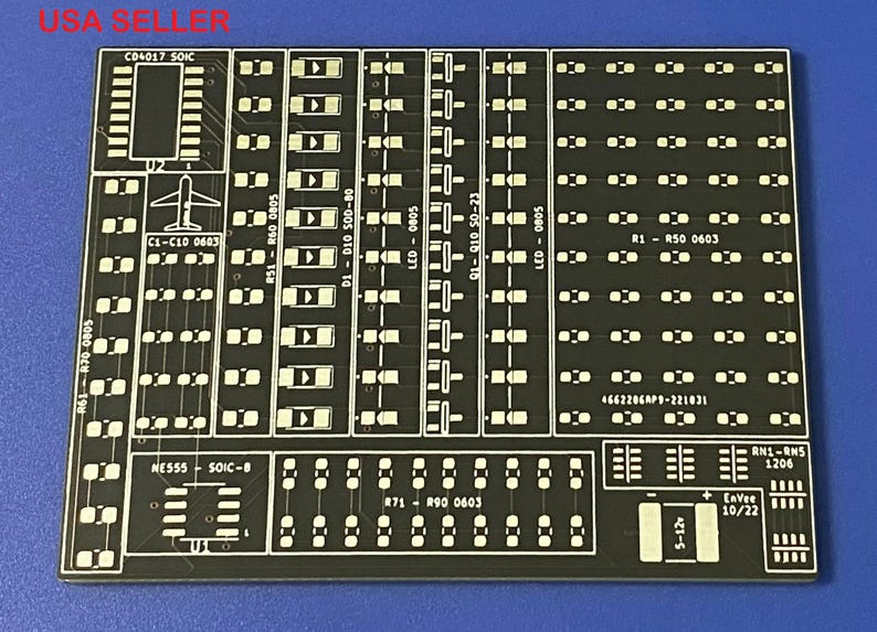 Puede incluir: Una placa de circuito impreso negra con texto y marcas blancas. La placa tiene una variedad de componentes, incluyendo resistencias, condensadores y circuitos integrados. El texto en la placa incluye "C04017 SOIC", "C1-C10 0603", "R50 0603", "NE555 SOIC-8", "871 R90 0603", "LED-080 0805", "91-910 50-23", "LED-0805", "4662206AP9-221031", "RN1-RNS 1206", "421-5", "10/22".