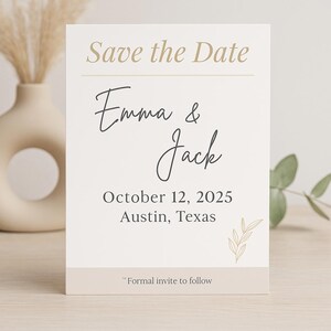 Op de afbeelding: Save the Date kaart met een witte achtergrond en gouden tekst. De kaart zegt "Save the Date" in gouden tekst, gevolgd door "Emma & Jack" in zwarte cursieve letters. De datum "12 oktober 2025" en de locatie "Austin, Texas" zijn in zwarte tekst gedrukt. De kaart heeft een klein gouden bladontwerp in de rechterbenedenhoek. De tekst "Formal invite to follow" is in zwarte tekst gedrukt aan de onderkant van de kaart.