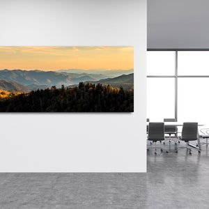 Puede incluir: Una fotograf&iacute;a panor&aacute;mica de una cordillera con un cielo azul y una puesta de sol dorada. Las monta&ntilde;as est&aacute;n cubiertas de &aacute;rboles y el cielo est&aacute; lleno de nubes. La imagen se toma desde un punto de vista elevado, mirando hacia el paisaje.