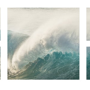 May include: A close-up of a large wave crashing in the ocean. The wave is white and foamy at the top, and the water is a deep blue.