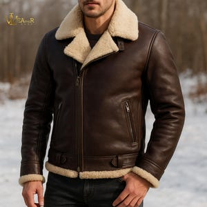 May include: A brown leather jacket with a cream shearling collar and lining. The jacket has a zip closure, two front pockets, and buckle details at the waist and cuffs. The jacket is designed for cold weather.