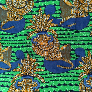 May include: Vibrant fabric with a repeating pattern of stylized orange and yellow floral elements and blue shapes against a green background with black wave-like lines. The design has a bold, graphic quality, suitable for various textile applications.