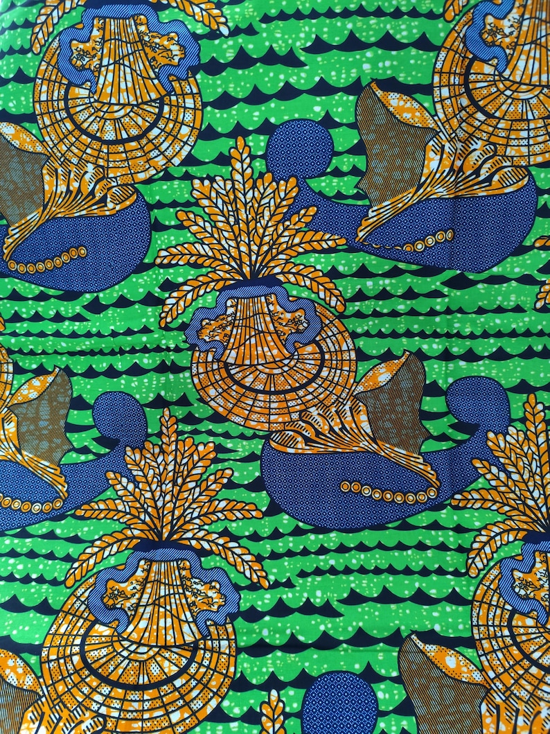May include: Vibrant fabric with a repeating pattern of stylized orange and yellow floral elements and blue shapes against a green background with black wave-like lines. The design has a bold, graphic quality, suitable for various textile applications.