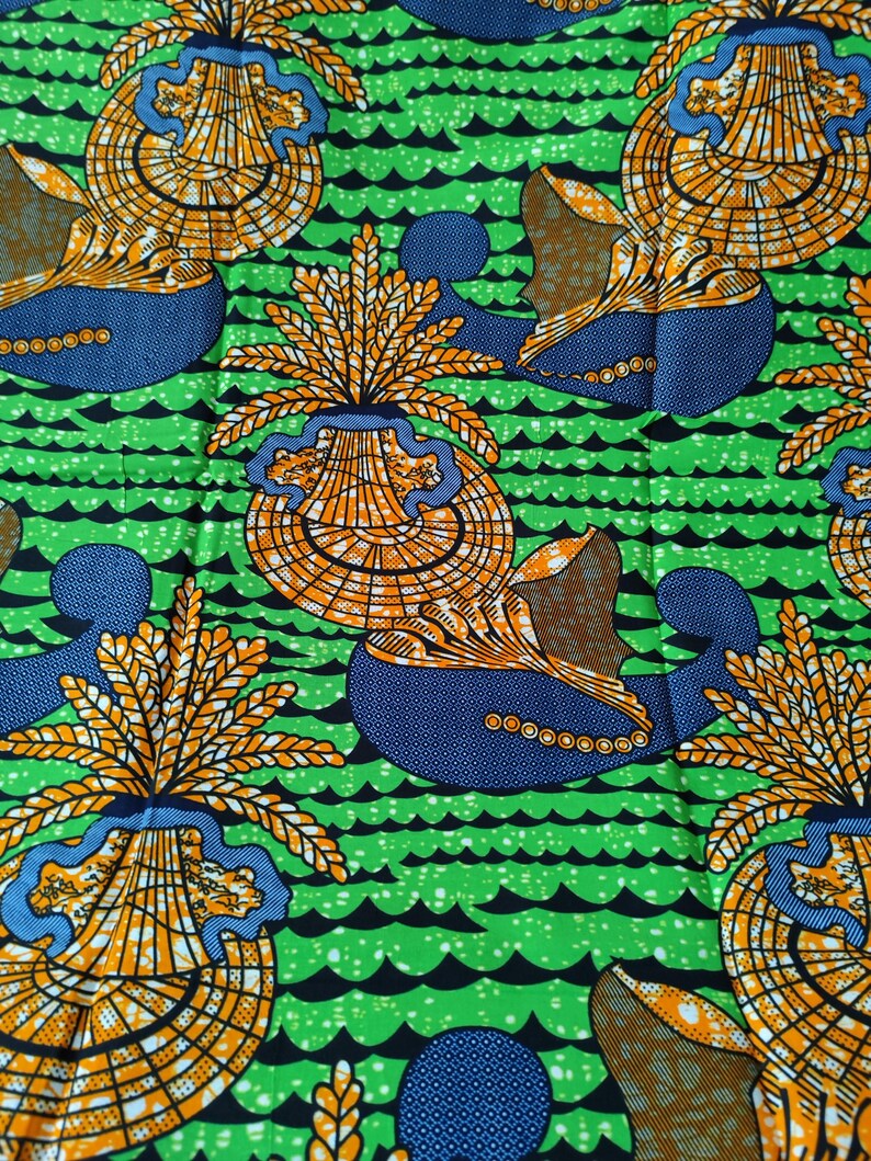 May include: Vibrant fabric featuring a repeating pattern of stylized seashell-like shapes in orange and yellow, set against a blue and brown background. The design is on a bright green background with black wave-like lines.