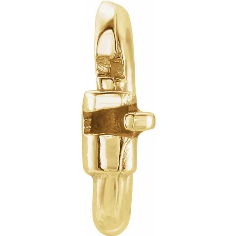 May include: Gold-toned metal charm with a square-shaped opening. The charm has a smooth, polished finish.