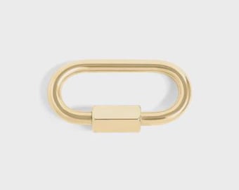 May include: A gold-colored, oval-shaped carabiner with a rectangular clasp. The carabiner is shown against a light gray background. The product is a jewelry component.