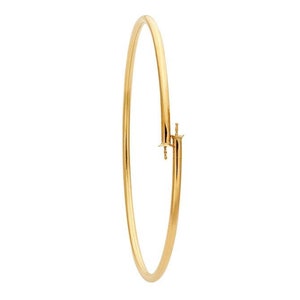 May include: A gold bangle bracelet with a hinged clasp.