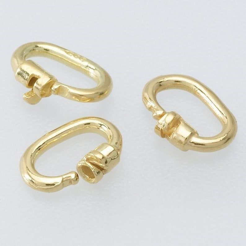 May include: Three gold-coloured oval-shaped jump rings with a twisted design. The jump rings are used for connecting jewellery pieces.