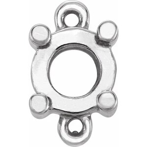 Może przedstawiać: Srebrny metalowy wisiorek z okrągłym otworem w środku i czterema szpilkami. Wisiorek ma dwie pętle u góry do przymocowania do łańcuszka lub sznurka.