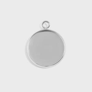 Puede incluir: Un colgante redondo de color plateado con un bisel elevado y un peque&ntilde;o lazo en la parte superior para sujetarlo a una cadena o cord&oacute;n. El colgante tiene una superficie lisa y reflectante, perfecto para a&ntilde;adir un dise&ntilde;o o imagen personalizado. El colgante se muestra sobre un fondo liso y claro.