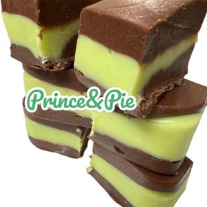May include: A stack of layered fudge pieces. Each piece has a light green center layer between two darker brown layers. The text "Prince & Pie" is in a green font on the image.