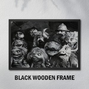 Puede incluir: Impresi&oacute;n en blanco y negro enmarcada que presenta una colecci&oacute;n de personajes de marionetas fant&aacute;sticas con diversas expresiones. La impresi&oacute;n est&aacute; en un marco de madera negra, con el texto "BLACK WOODEN FRAME" en la parte inferior.