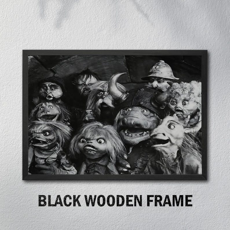 Puede incluir: Impresi&oacute;n en blanco y negro enmarcada que presenta una colecci&oacute;n de personajes de marionetas fant&aacute;sticas con diversas expresiones. La impresi&oacute;n est&aacute; en un marco de madera negra, con el texto "BLACK WOODEN FRAME" en la parte inferior.
